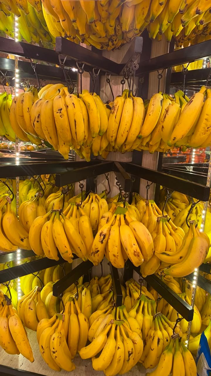 Cachos de banana pendurados no expositor